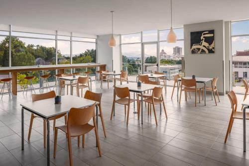 a restaurant with tables and chairs and windows at Element Asheville Downtown in Asheville