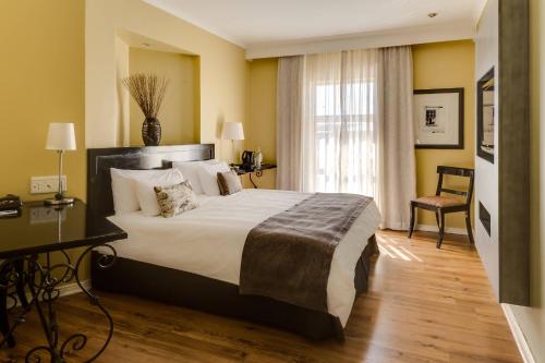 Habitación de hotel con cama grande y ventana en Protea Hotel by Marriott Bloemfontein, en Bloemfontein