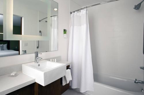 y baño blanco con lavabo y ducha. en SpringHill Suites by Marriott Mobile West, en Mobile