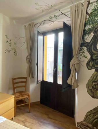 a room with a door and a chair and a window at Antico Borgo - A due passi dalle Gole Alcantara in Motta Camastra