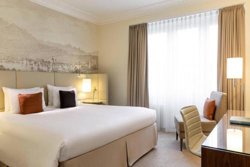a hotel room with a large bed and a window at Renaissance Lucerne Hotel in Luzern