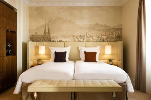a bedroom with a large bed with a painting on the wall at Renaissance Lucerne Hotel in Luzern