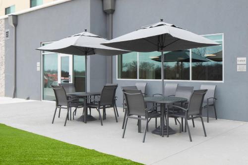 a table and chairs with umbrellas on a patio at Fairfield by Marriott Inn & Suites Dallas McKinney in McKinney