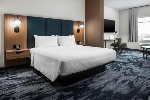 una camera d'albergo con un grande letto e una scrivania di Fairfield by Marriott Inn & Suites Dallas McKinney a McKinney