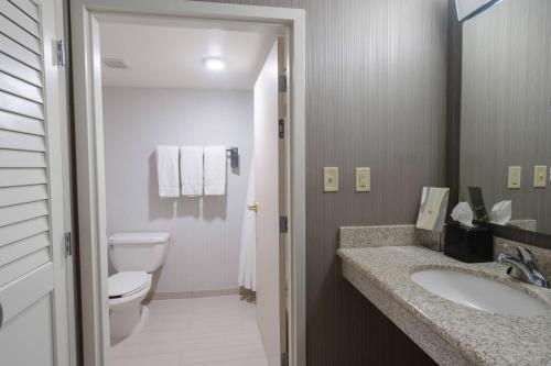 y baño con aseo y lavamanos. en Courtyard by Marriott Cleveland Willoughby en Willoughby