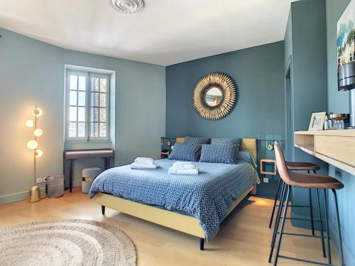 Dormitorio azul con cama y espejo en Les Cimes du Puy-en-Velay, en Le Puy en Velay