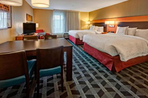TownePlace Suites by Marriott Hattiesburg في هاتييسبورغ: غرفة فندقية بسريرين وطاولة وكراسي