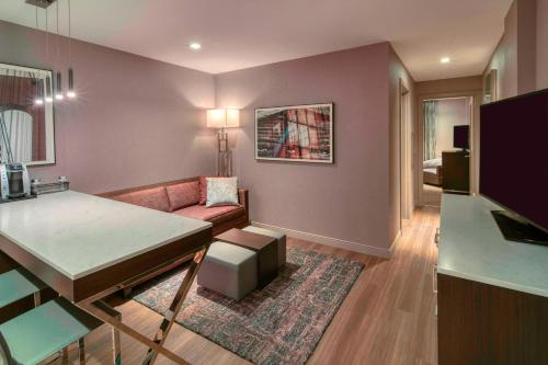 Residence Inn by Marriott Weehawken في ويهاوكن: غرفة معيشة مع أريكة وطاولة