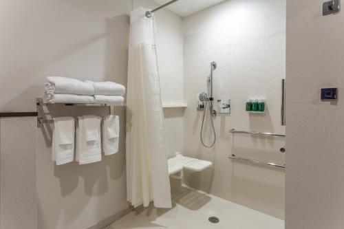 a bathroom with a shower and a toilet and towels at Fairfield Inn & Suites Franklin in Franklin