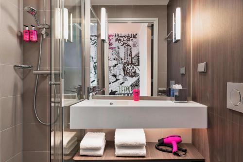 a bathroom with a sink and a shower at Moxy Copenhagen Sydhavnen in Copenhagen