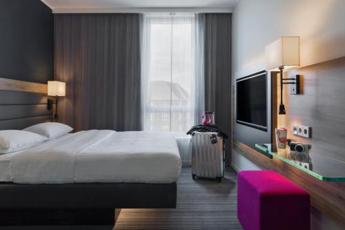 a hotel room with a bed and a large window at Moxy Copenhagen Sydhavnen in Copenhagen