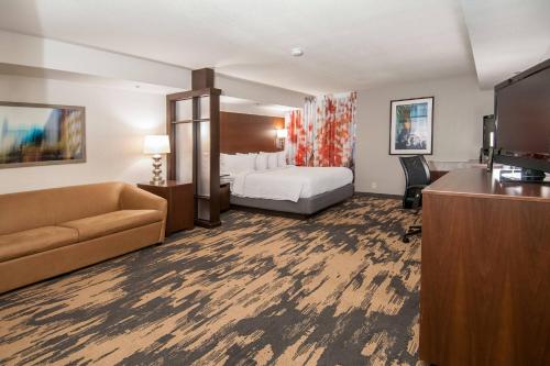 Fairfield Inn & Suites by Marriott Dallas DFW Airport South/Irving في ايرفينغ: غرفه فندقيه بسرير واريكه