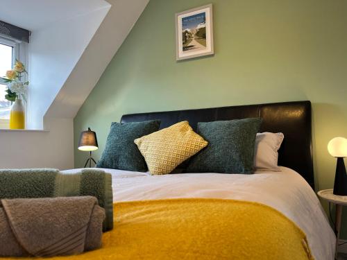 1 dormitorio con 1 cama con almohadas azules y amarillas en Hidden Gem with Free Parking en Windsor