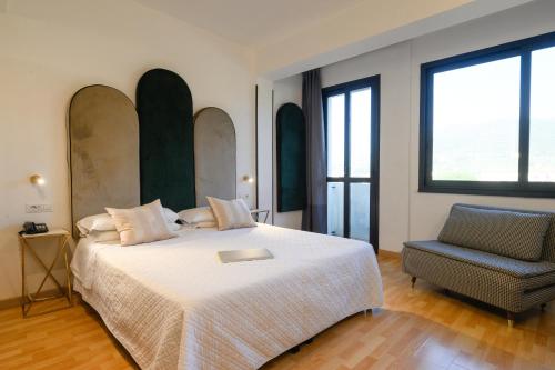 a bedroom with a large bed and a chair at Art Hotel Milano in Prato