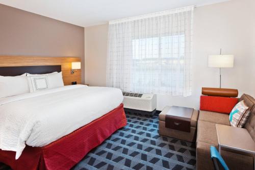 um quarto de hotel com uma cama grande e um sofá em TownePlace Suites Dothan em Dothan