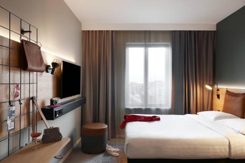 a hotel room with a large bed and a window at Moxy Edinburgh Fountainbridge in Edinburgh