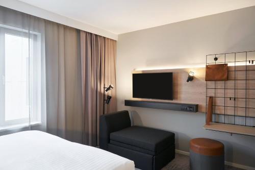 a hotel room with a bed and a chair and a tv at Moxy Edinburgh Fountainbridge in Edinburgh