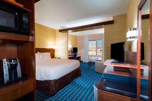a hotel room with a bed and a television at Fairfield by Marriott Inn & Suites Palm Desert Coachella Valley in Palm Desert