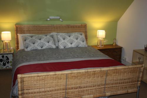 a bedroom with a large wicker bed with two lamps at Gite de Sarah 