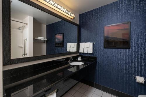 a bathroom with a sink and a large mirror at Fairfield Inn and Suites by Marriott New Bedford in New Bedford