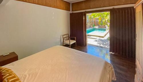 1 dormitorio con cama y vistas a la piscina en The Lavana Villa Sutji Sanur, en Sanur
