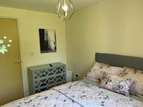 a bedroom with a bed and a chandelier at Modern Beautiful Gated Two Bed Apartment in Stifford