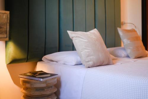 a bedroom with two beds with white pillows and a book at Art Hotel Milano in Prato