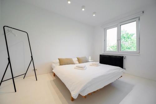 ein weißes Schlafzimmer mit einem Bett und einem Spiegel in der Unterkunft Piestany Waltari Apartment in Piešťany