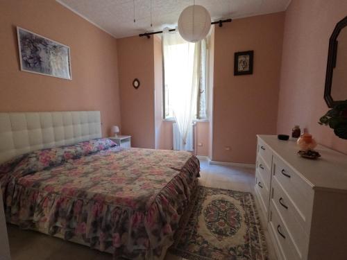 a bedroom with a bed and a dresser and a window at Casa Elsi in Lido di Ostia