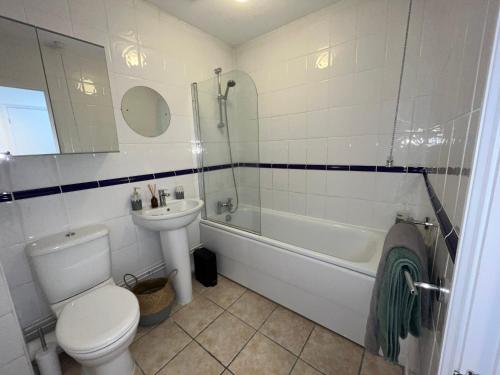 een badkamer met een toilet, een wastafel en een bad bij Hidden Gem with Free Parking in Windsor