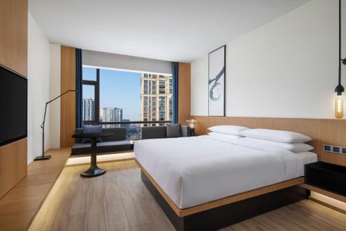 a bedroom with a white bed and a large window at Fairfield by Marriott Hangzhou Xiaoshan in Hangzhou