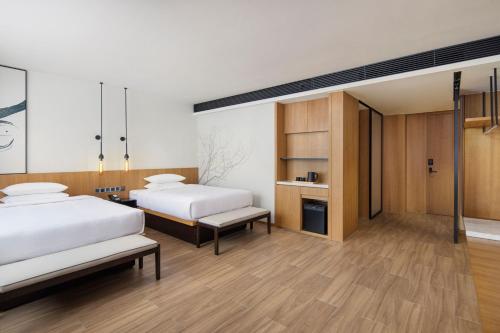 two beds in a room with wooden floors at Fairfield by Marriott Hangzhou Xiaoshan in Hangzhou