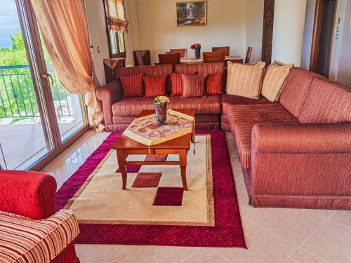 uma sala de estar com sofás vermelhos e uma mesa de centro em Villa Etheras - Nested between Nature by Amazing View - 5 mins from Edessa em Édessa