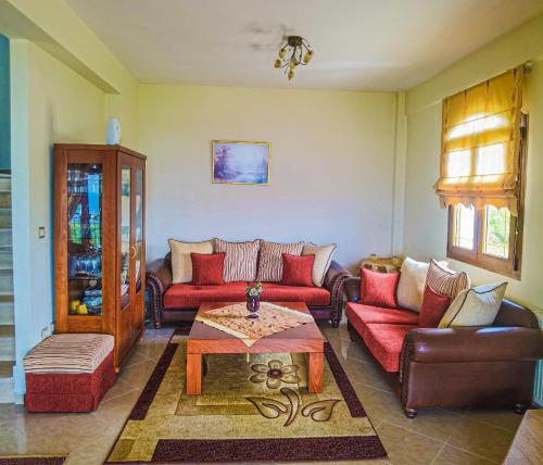 a living room with red couches and a coffee table at Villa Etheras - Nested between Nature by Amazing View - 5 mins from Edessa in Edessa