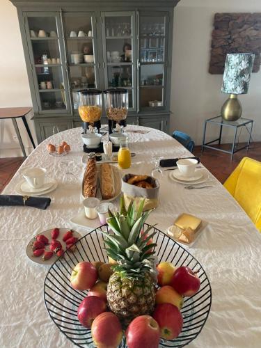 a table with a plate of fruit on it at Les Cimes du Puy-en-Velay in Le Puy en Velay