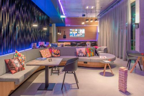 a lobby with a couch and a table and chairs at Moxy Munich Messe in Aschheim