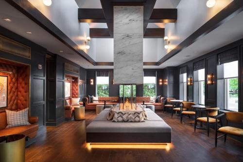 a lobby with a fireplace in the middle of a room at The Union Club Hotel at Purdue University, Autograph Collection in West Lafayette