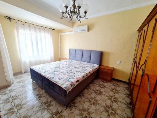 Schlafzimmer mit einem Bett und einem Kronleuchter in der Unterkunft Apartamento en Santa Pola playa Levante in Santa Pola