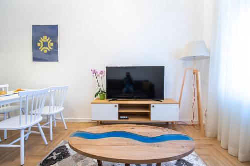 a living room with a tv and a table at Luxury Suite in City Centre in Sarajevo