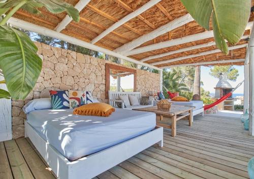 eine Veranda mit einem Bett und einer Hängematte auf einem Holzdeck in der Unterkunft Villa La Residence Ibiza in San Jose de sa Talaia