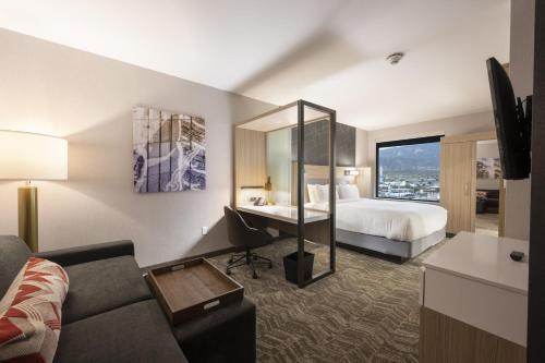 um quarto de hotel com uma cama e uma secretária em SpringHill Suites by Marriott Colorado Springs Downtown em Colorado Springs