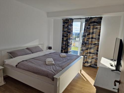 a bedroom with a bed and a television and a window at Cluj CITY Vibe in Cluj-Napoca