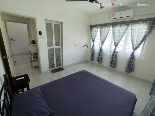 um quarto com uma cama azul num quarto em Homestay Nilai D'Jati em Nilai