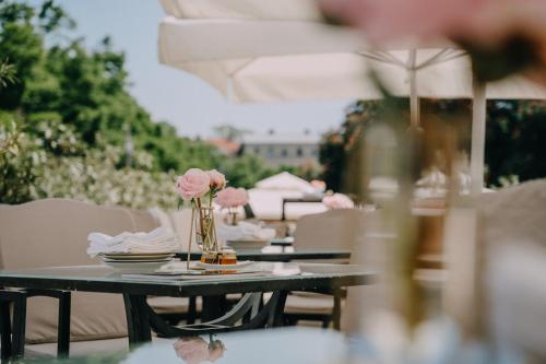 a table with a vase of pink flowers on it at Esplanade Zagreb Hotel in Zagreb