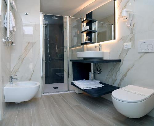 a bathroom with a toilet and a sink and a shower at Hotel Orchidea in Bardolino
