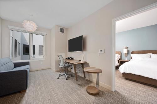 a hotel room with a bed and a desk with a computer at Element Hampton Peninsula Town Center in Hampton