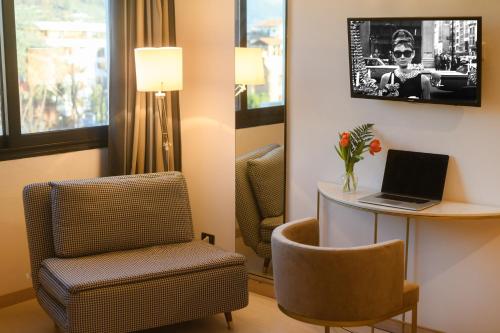a room with a chair and a desk with a laptop at Art Hotel Milano in Prato