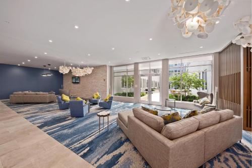 a living room with a couch and chairs and a chandelier at Element Hampton Peninsula Town Center in Hampton