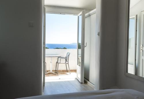 a bedroom with a view of a table and chairs at Hôtel Beau Site in Le Lavandou