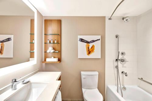 een badkamer met een wastafel, een toilet en een bad bij Delta Hotels by Marriott Calgary Downtown in Calgary